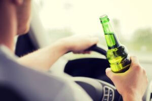 man drinking alcohol while driving the car